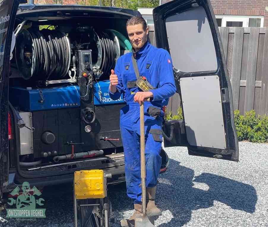 Een tevreden monteur met opgestoken duim naast de bestelbus, slim ingrijpen bespaart kosten bij een verstopte afvoer in Veghel