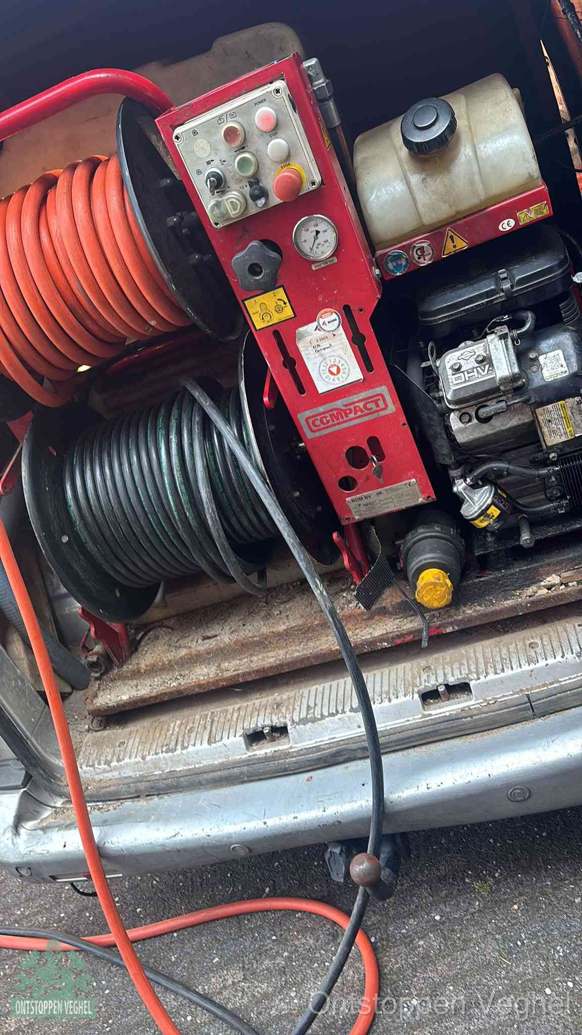 Een rood hogedruk-rioolreinigingstoestel in de laadbak van de bedrijfsbus, apparatuur voor een hardnekkige afvoerverstopping in Veghel