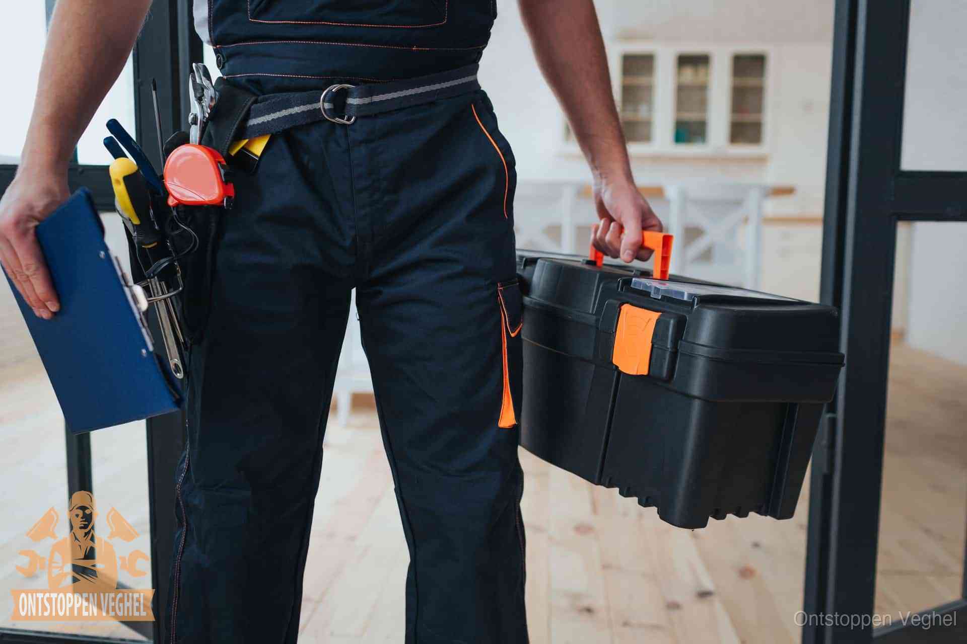 Een monteur met gereedschapsriem en klembord in een keuken, klaar om een transparante prijs voor het gootsteen ontstoppen in Veghel te geven