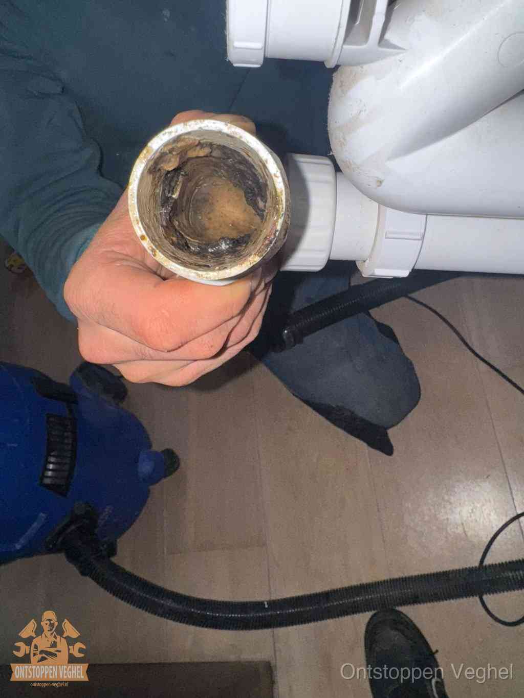 Een losgekoppelde afvoerbuis die van binnen volledig is dichtgeslibd met vet en aanslag, de meest voorkomende oorzaak van een verstopte gootsteen in Veghel