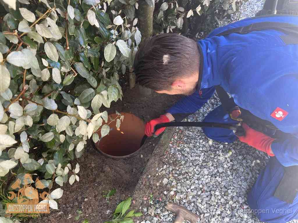Monteur reinigt een rioolput met een slang, periodieke rioolreiniging in Veghel