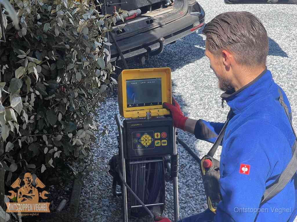 Monteur bedient een rioolinspectiecamera met monitor voor rioolinspectie in Veghel