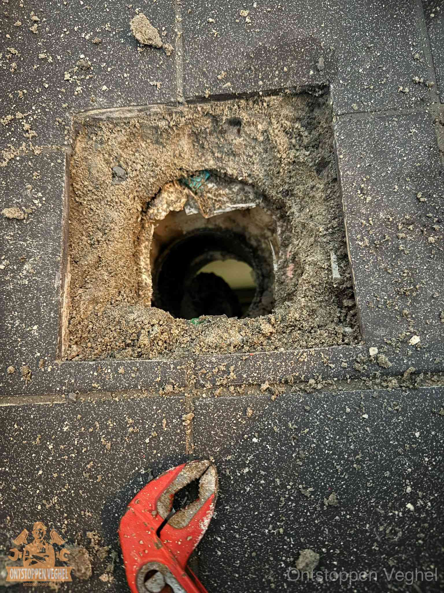 Geopend rioolputje op de erfgrens dat laat zien wie eigenaar is van de riolering in Veghel