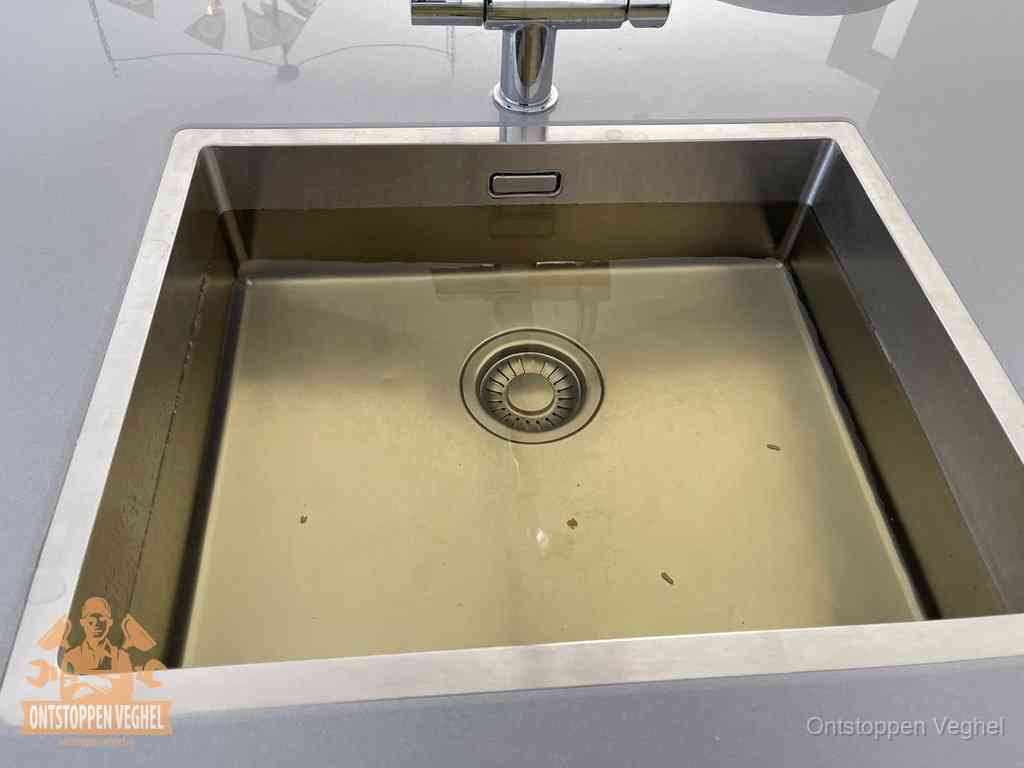 Stilstaand water in een rvs spoelbak dat niet wegloopt, een duidelijk signaal van een gootsteenverstopping in Veghel