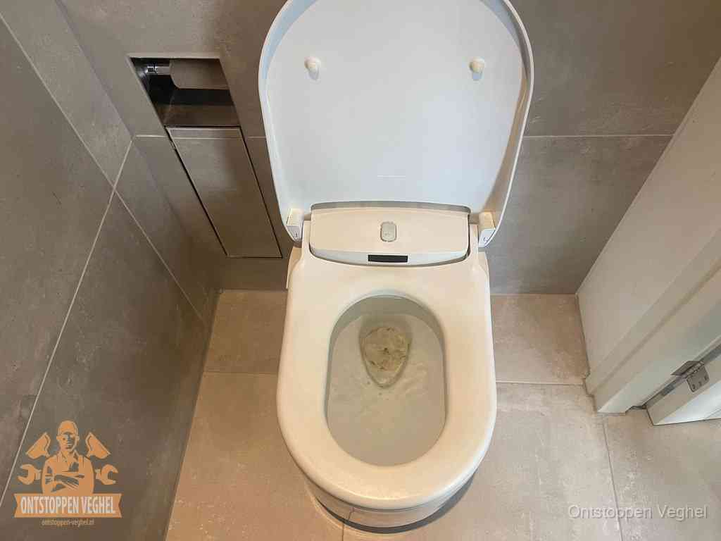 Signalen van een verstopte wc herkennen in Veghel Een wit hangtoilet waarin een prop wc-papier op het water blijft drijven, een duidelijk signaal van een verstopte wc in Veghel