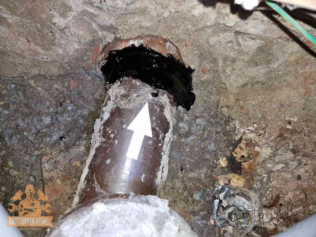 Structurele afvoerproblemen met het toilet in Veghel Een oude gres rioolbuis met een beschadigde koppeling onder de vloer, oorzaak van terugkerende structurele wc-problemen in Veghel