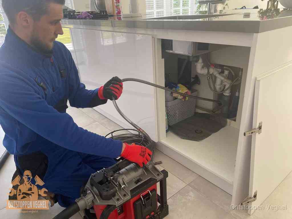 Een monteur reinigt de keukenafvoer grondig met een veermachine om terugkerende gootsteenverstoppingen te voorkomen in Veghel
