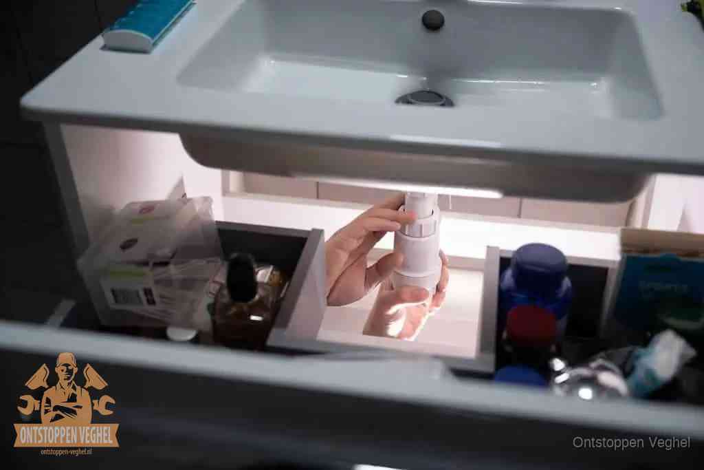 Wc ontstoppen met warm water en afwasmiddel in Veghel Een pompfles met zeep boven een wastafel in de toiletruimte, de warm water en afwasmiddel-methode om de wc te ontstoppen in Veghel