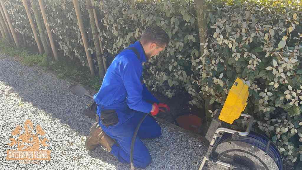 Monteur aan het werk bij een rioolput, de werkwijze voor riool ontstoppen in Veghel